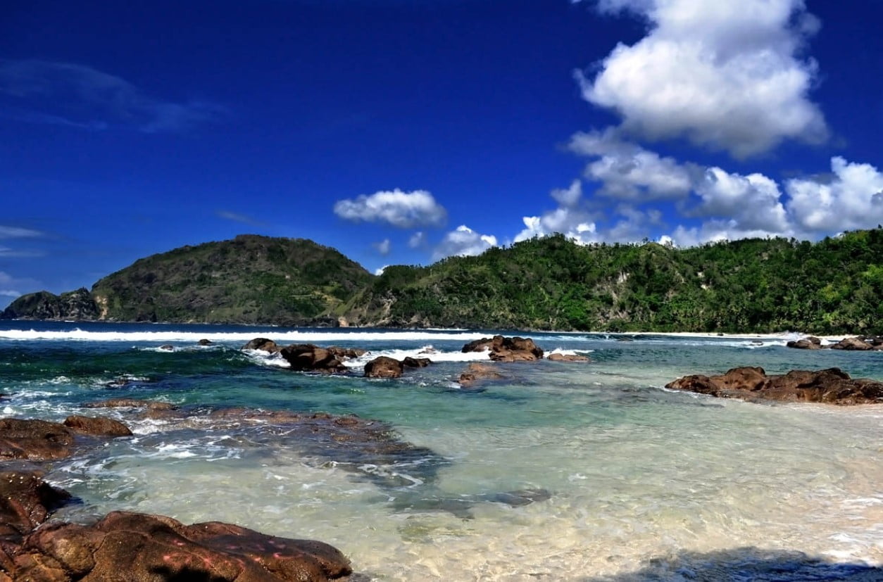 Pemandangan indah Pantai Wedi Ombo dengan pasir putih yang luas dan formasi batu karang yang unik